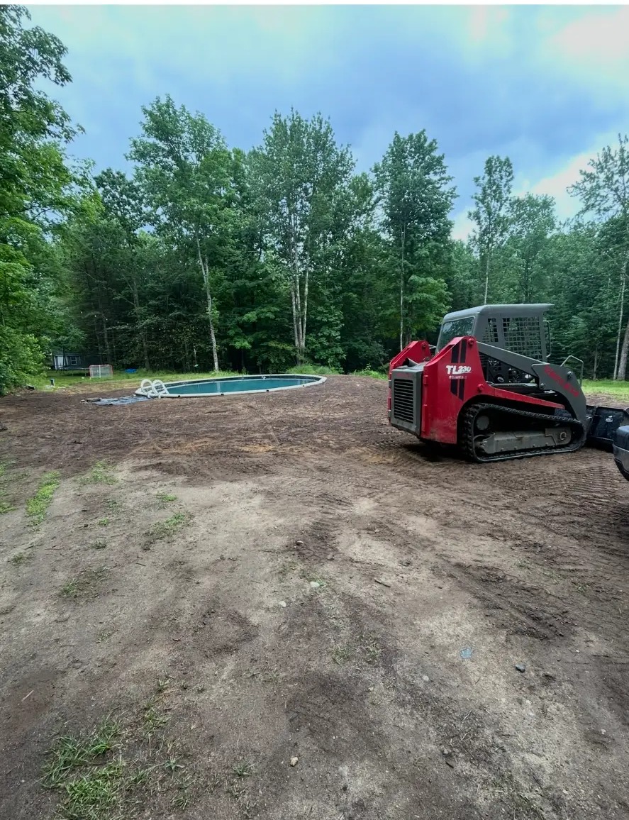 Track loader grading soil around a newly installed in-ground pool
