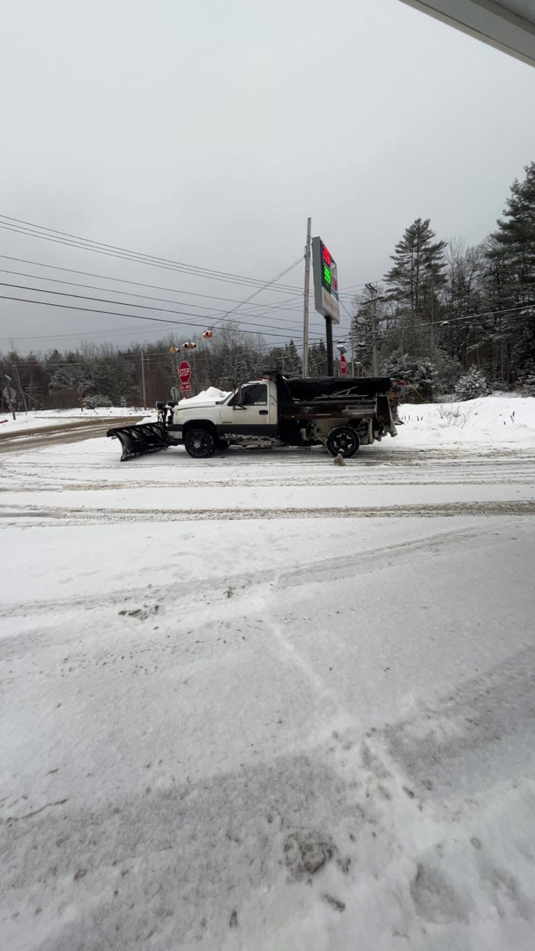 Plow truck clearing snow from a lot in winter