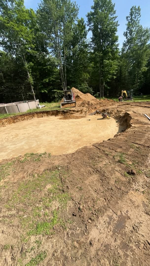 Excavated and graded house pad with equipment on a Central Maine property