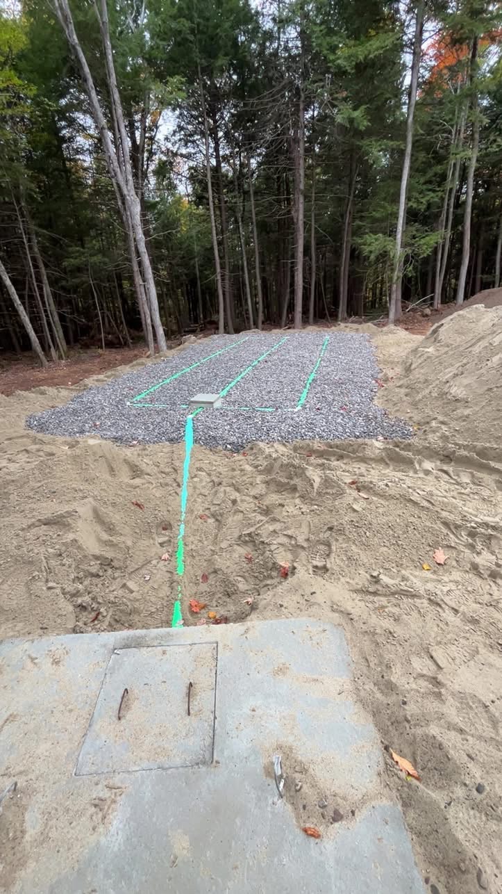 Stone leach field bed and septic tank cover during a septic system installation